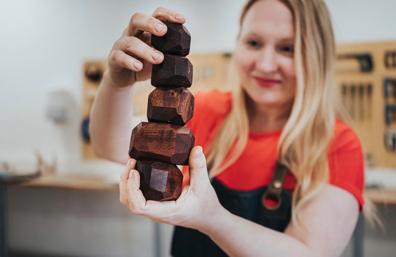 Wood Sisters teacher holding a stack of hand-carved wooden blocks